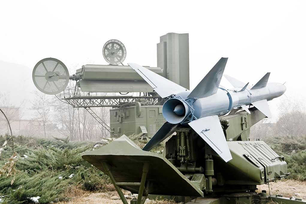 Military missile launcher with radar systems in a foggy field